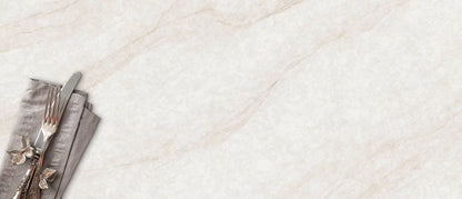 A knife and fork rest on a gray napkin atop MSI IvoriTaj Polished Quartz, a light surface with beige veining, lower left corner.